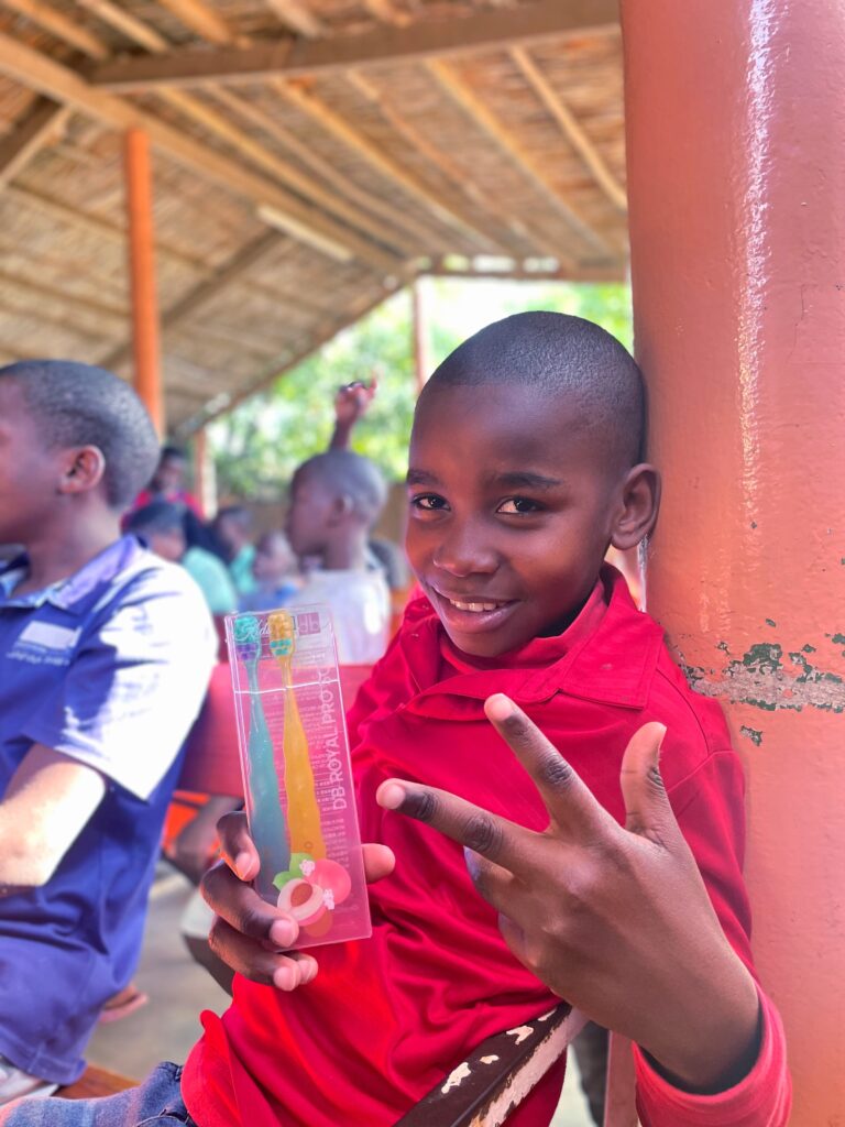 The child smiles in front of the camera.