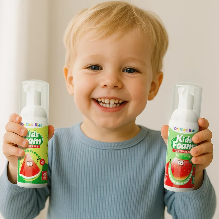 A smiling toddler (age 2–5) holding OralGos Tooth Mousse with both hands