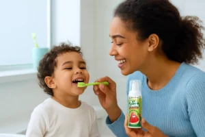 Parent teaching kids oral care by brushing with fluoride toothpaste in a bright bathroom