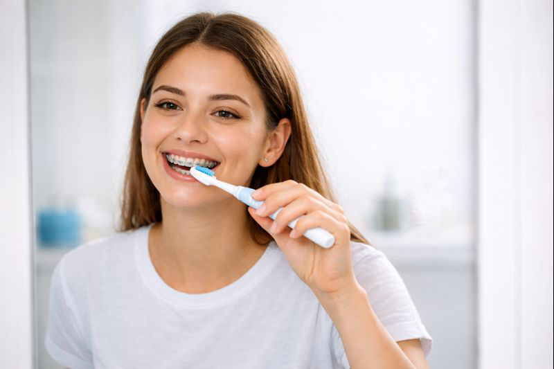 Oral care routine for braces patients brushing teeth with orthodontic toothbrush
