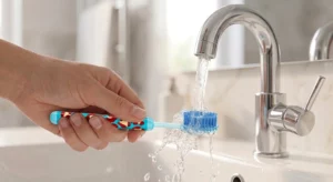 Demonstration of how to clean a toothbrush under running warm water