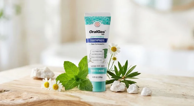 A tube of Oralgos DB865 Fluoride-Free Toothpaste surrounded by fresh mint leaves and minerals, highlighting natural ingredients.