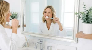 A person with a healthy smile brushing teeth gently to prevent bleeding gums